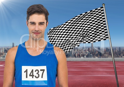 Male runner with number on shirt on track against skyline and checkered flag