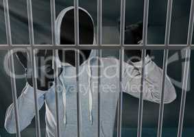 Anonymous Criminal in hood behind prison bars