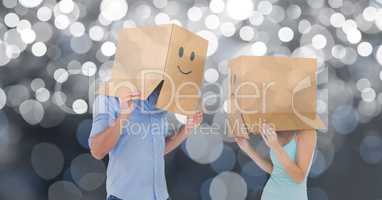 Couple with emojis on cardboard boxes over bokeh background