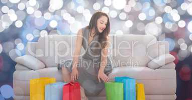 Woman with shopping bags sitting on sofa