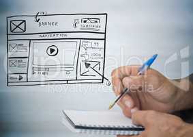 Hands with pen and notepad against website mock up against blurry grey wood panel