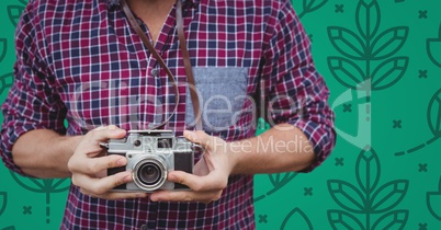 Man mid section with camera against green nature pattern