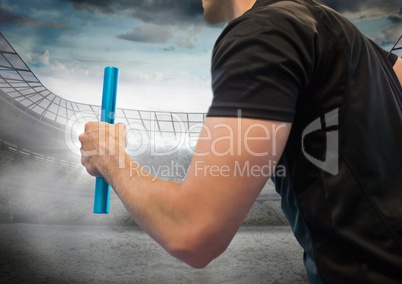 Hand with blue baton against stadium with flares