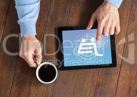 Man using Tablet with Shopping trolley icon and coffee