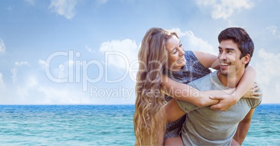 Happy man giving piggyback ride to woman at beach