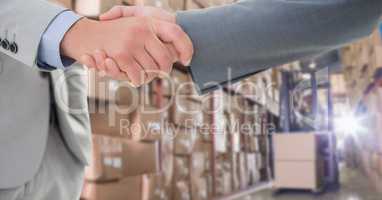 Cropped image of businessmen doing handshake in warehouse
