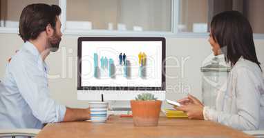 Side view of business people looking at graph on screen