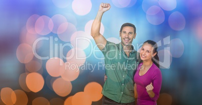 Happy couple celebrating success over bokeh