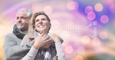 Happy couple in warm clothing against bokeh