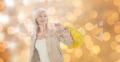 Woman holding shopping bags while looking away