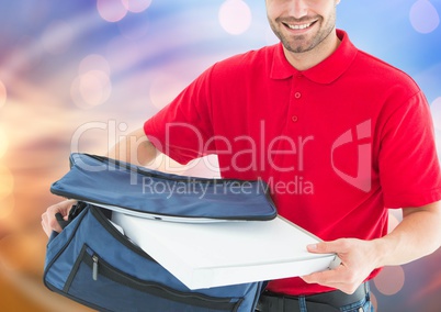 Happy deliveryman with the delivery bag and pizza boxes. Lights background