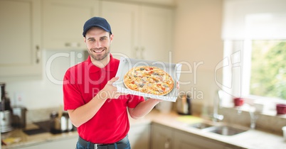 Delivery man holding pizza in box at home
