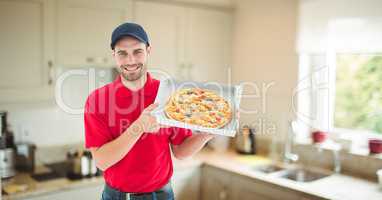 Delivery man holding pizza in box at home