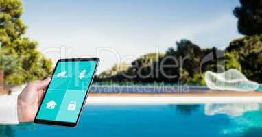 Hand using smart home application on tablet PC at poolside