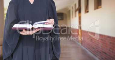 Judge holding book in front of corridor