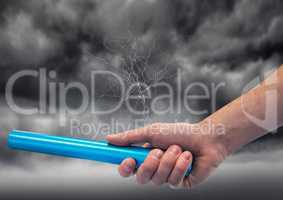 Hand with blue baton and lightning against stormy sky