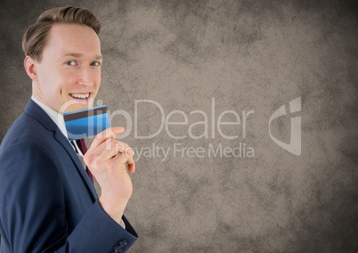 Business man with credit card against brown grunge background