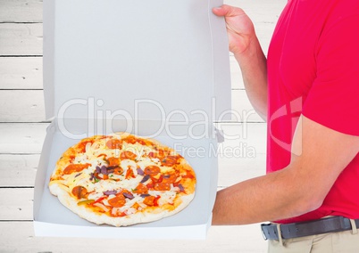 Foreground of the pizza in the box with the deliveryman. wood background