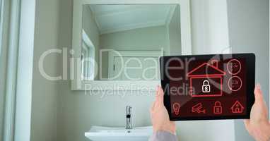 Hands using smart home application on digital tablet in washroom