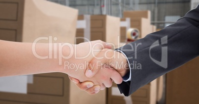 Cropped image of business people doing handshake in warehouse