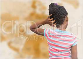 Back of girl with hand on head against blurry brown map