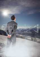 Business man with mist standing looking at mountains