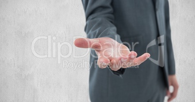 Midsection of businessman gesturing against wall