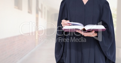 Judge holding book in front of bright building