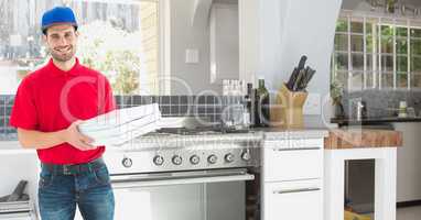 Delivery man holding pizza boxes in kitchen