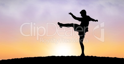 Silhouette man exercising against sky during sunset