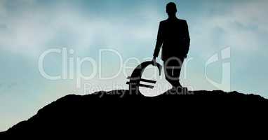 Businessman leaning on euro sign against sky