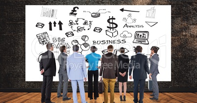 Business people looking at various icons on billboard against wall