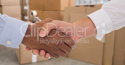 Business people shaking hands in warehouse
