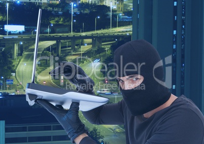 Criminal Man in hood in front of city lights