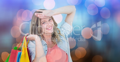 Happy woman with shopping bags over bokeh