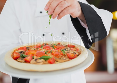 Chef with the pizza in foregroun,  in the restaurant. pizza delivery