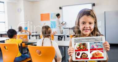 Happy girl holding digital tablet with restaurant site on screen in classroom