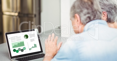 Senior business couple looking at graph and chart in laptop