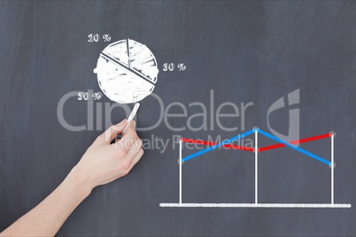 Cropped image of hand drawing pie chart by graph on blackboard