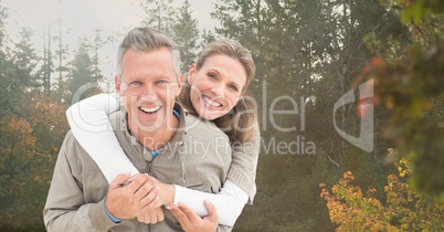 happy couple in front of trees