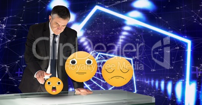 Digitally generated image of emojis flying by businessman touching futuristic desk