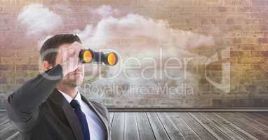 Businessman looking through binoculars on boardwalk