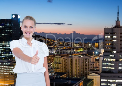 Business woman in front of the city at night with thumb up