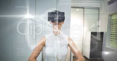 Digital composite image of tech graphics with businesswoman using VR glasses in office