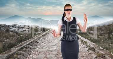 Business woman blindfolded walking down road
