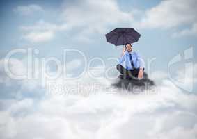 Business man legs crossed with umbrella on mountain peak in the clouds