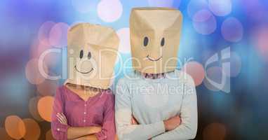 Couple wearing paper bags on head with smiles drawn on it