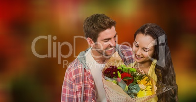 Couple with flower bouquet over blur background