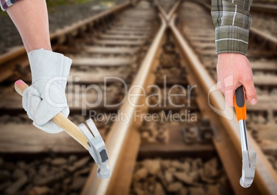 hands with hammers in the railroad tracks