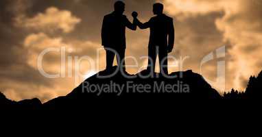 Silhouette businessmen holding hands during sunset